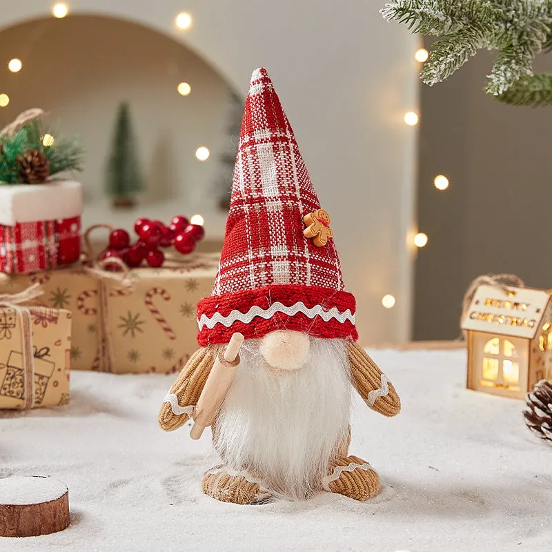Cloth gingerbread man Christmas ornament with red hat hanging on festive branch