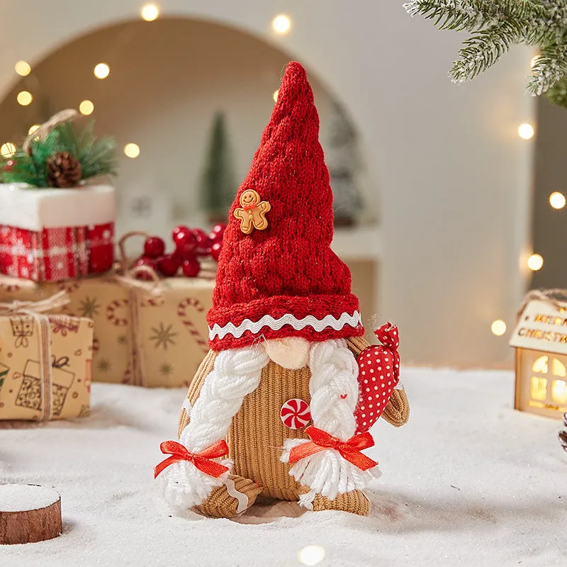 Cloth gingerbread man Christmas ornament with red hat hanging on festive branch