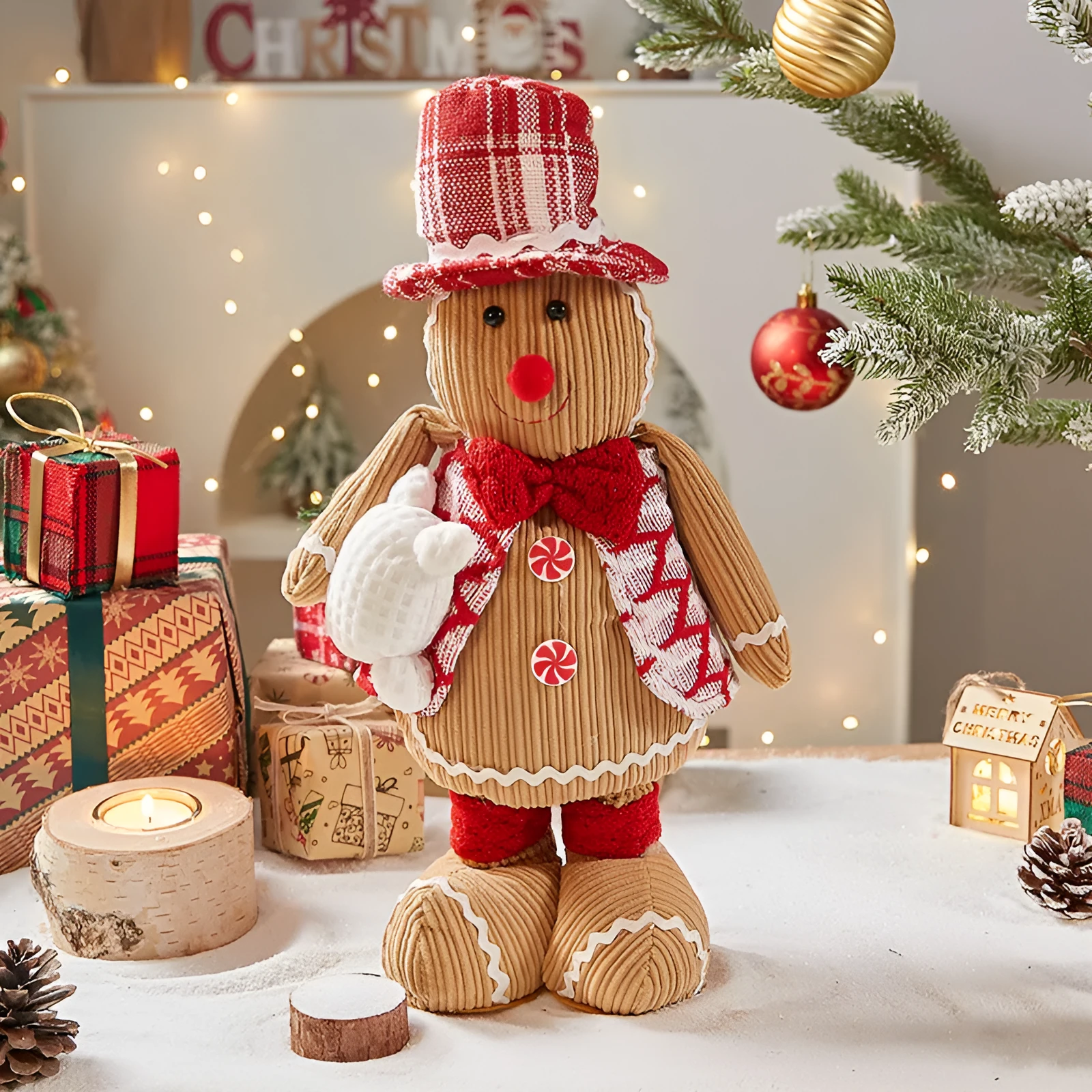 Cloth gingerbread man Christmas ornament with red hat hanging on festive branch