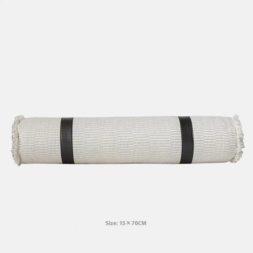 Modern grey and white plaid bed runner blanket set with round leather pillow on a bed.