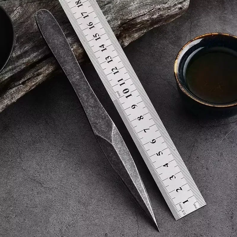Black stainless steel hand pry tea knife with pointed blade on plain background