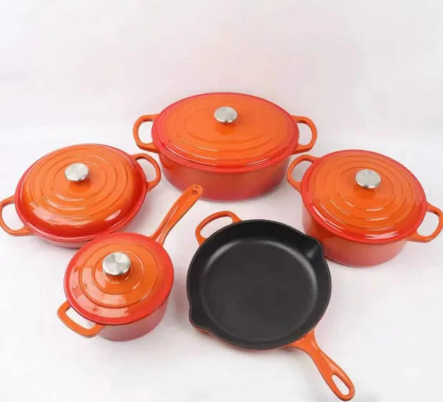 Cast iron enamel casserole set with frying pan and stew pot in light blue colour on a wooden table