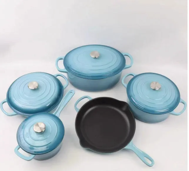 Cast iron enamel casserole set with frying pan and stew pot in light blue colour on a wooden table