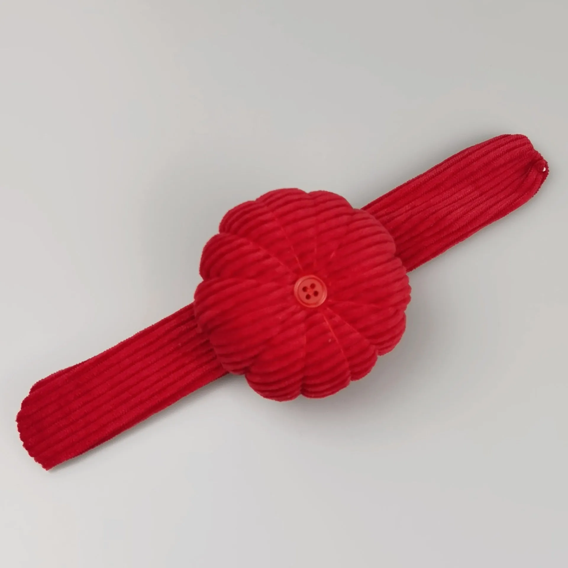 Ring pincushion sewing tool with vertical cutting slot in caramel colour showing fabric cushion and metal ring base