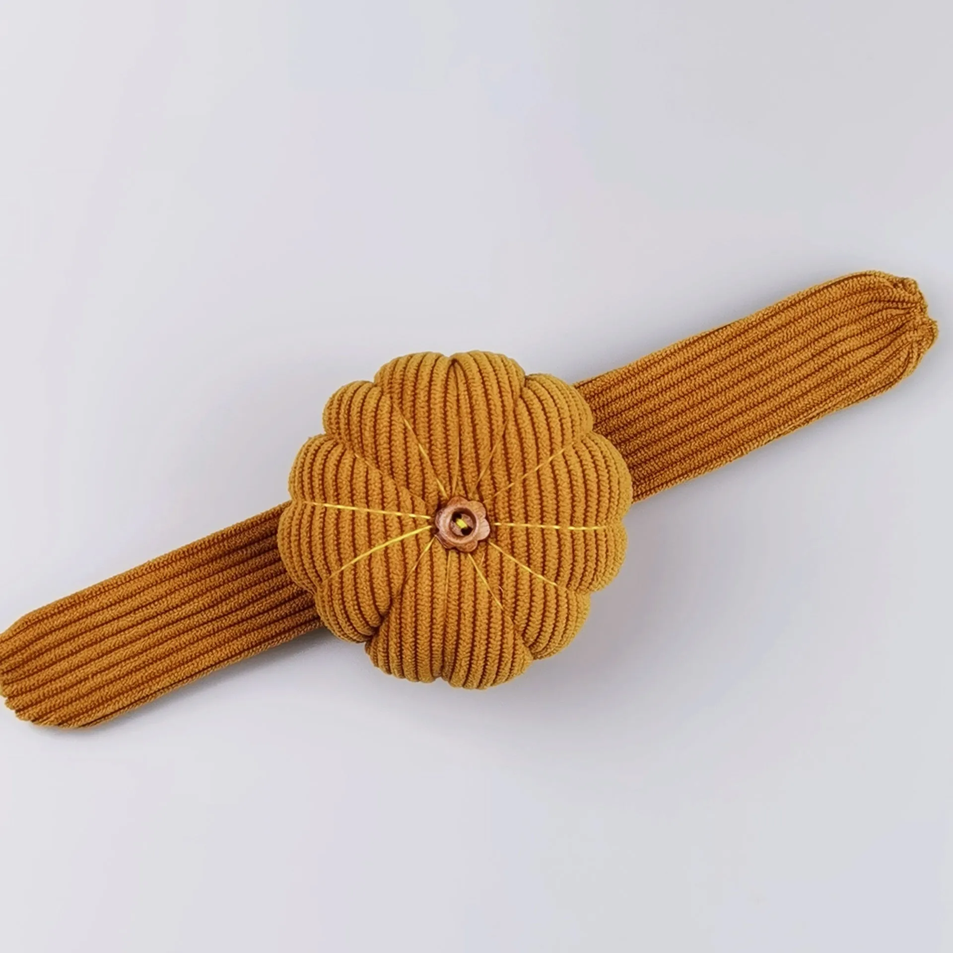 Ring pincushion sewing tool with vertical cutting slot in caramel colour showing fabric cushion and metal ring base