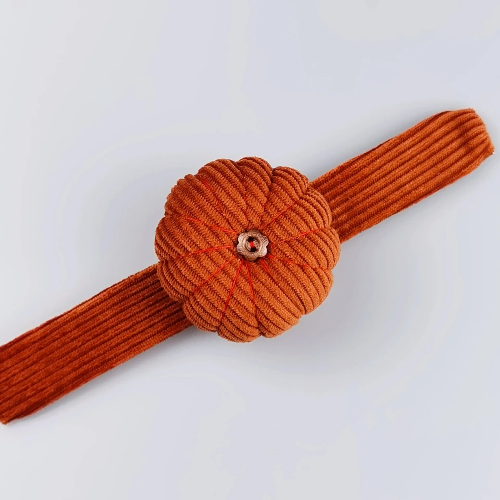 Ring pincushion sewing tool with vertical cutting slot in caramel colour showing fabric cushion and metal ring base