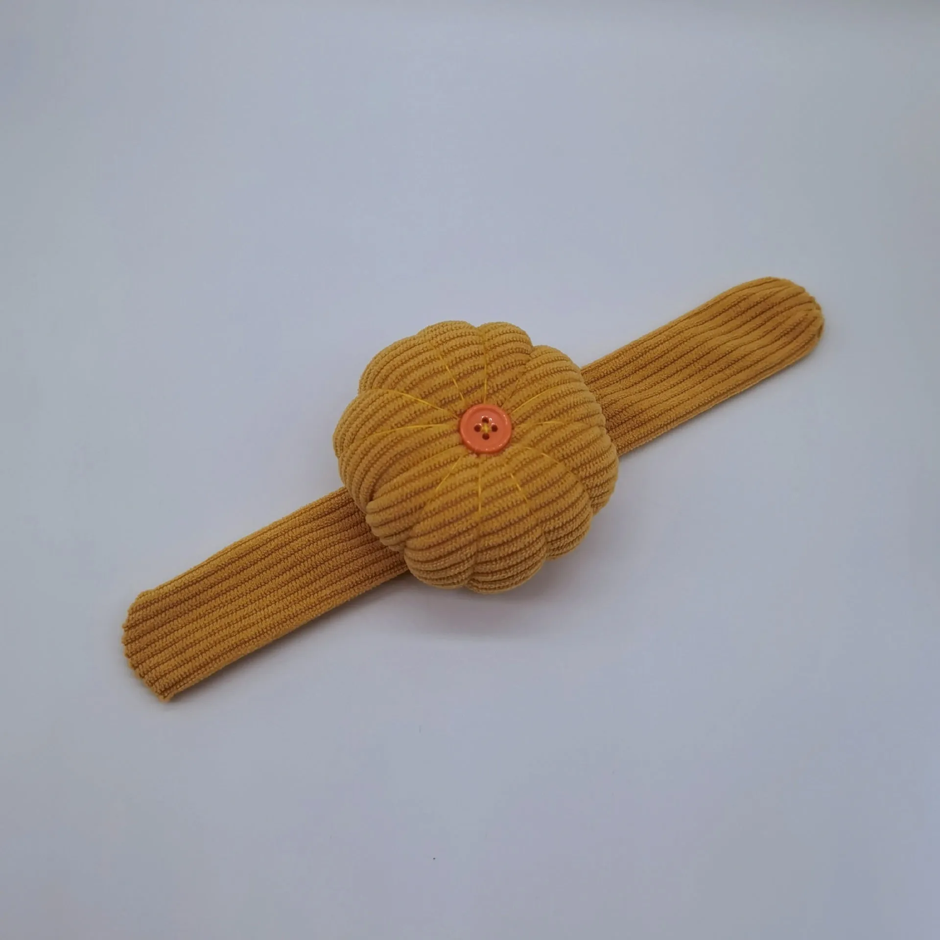 Ring pincushion sewing tool with vertical cutting slot in caramel colour showing fabric cushion and metal ring base