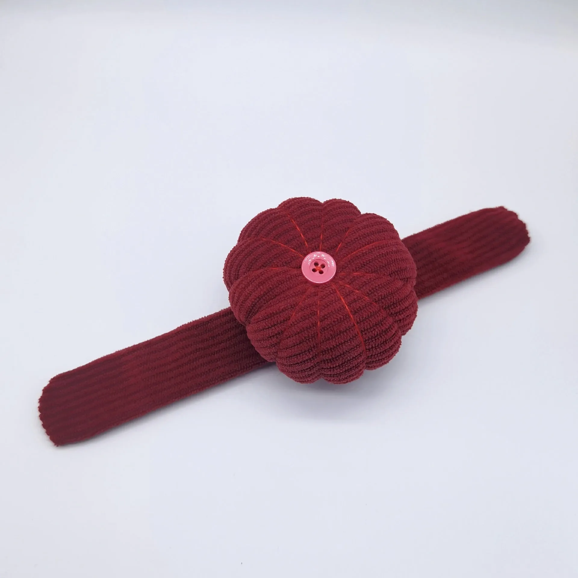 Ring pincushion sewing tool with vertical cutting slot in caramel colour showing fabric cushion and metal ring base