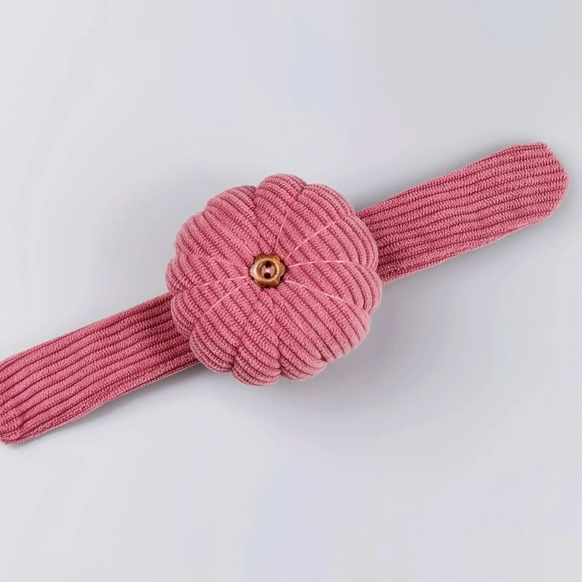 Ring pincushion sewing tool with vertical cutting slot in caramel colour showing fabric cushion and metal ring base