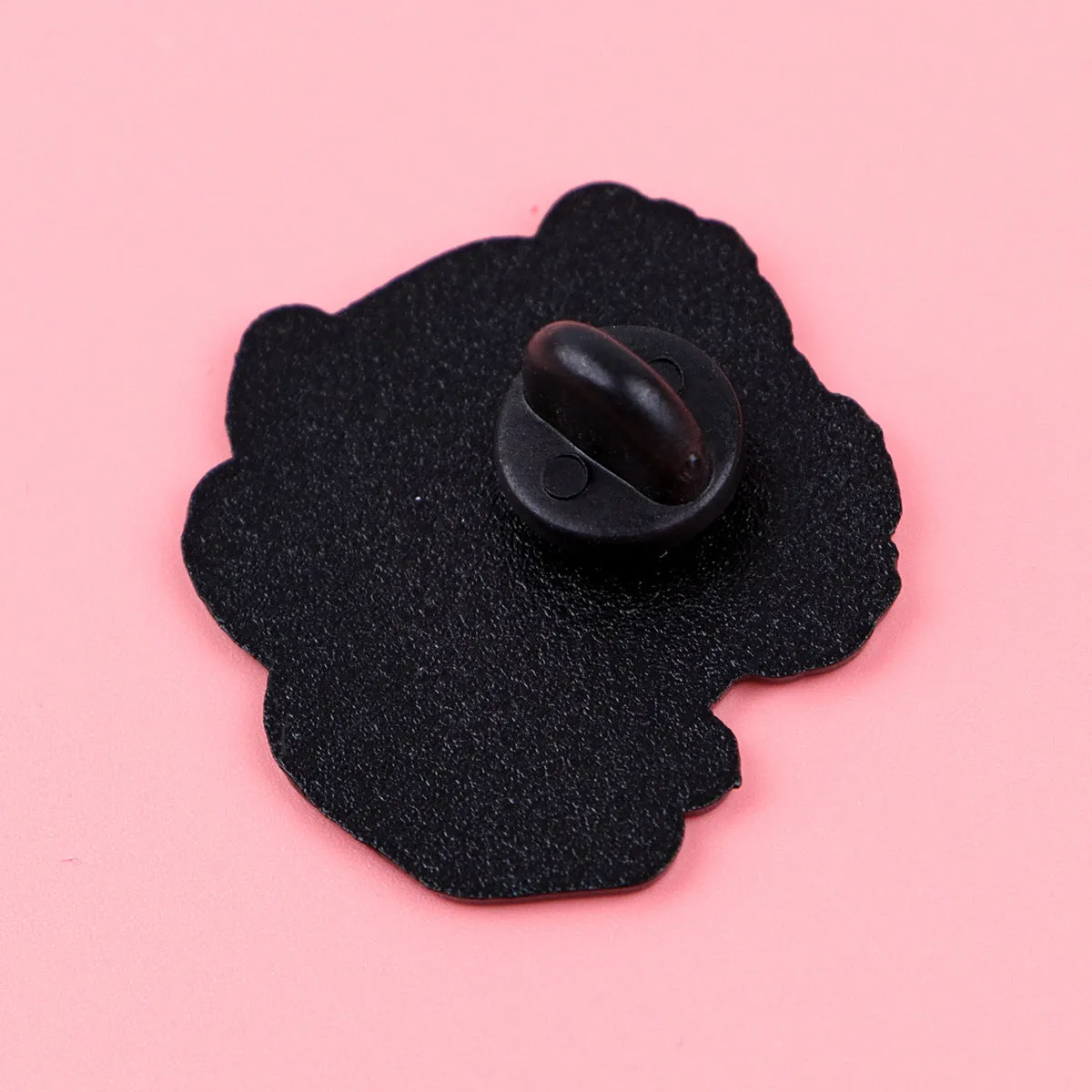 Cat shaped alloy brooch with dripping oil finish on a neutral background showing the pin clasp.