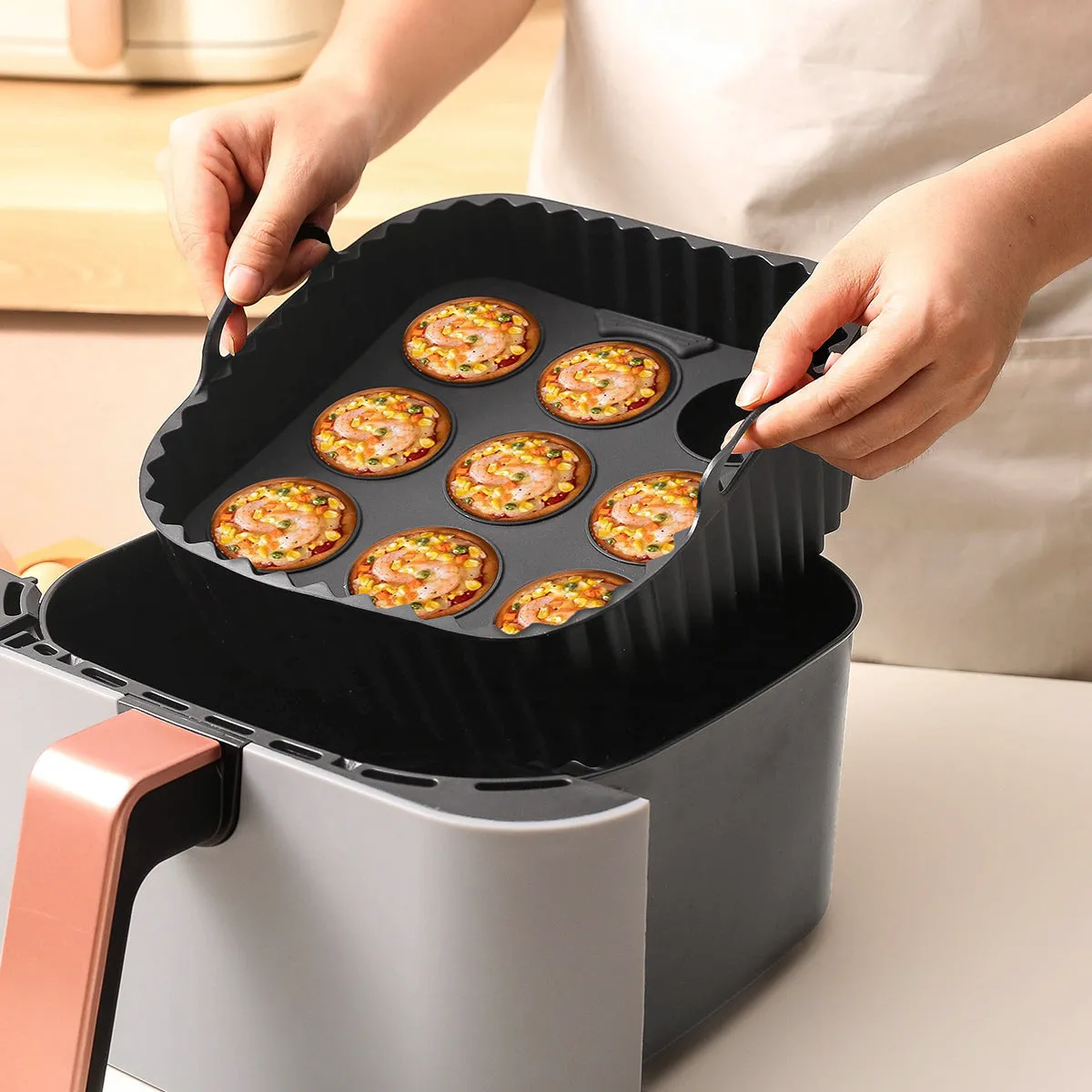 Black silicone square baking tray set for air fryer, 4 pieces on a light background