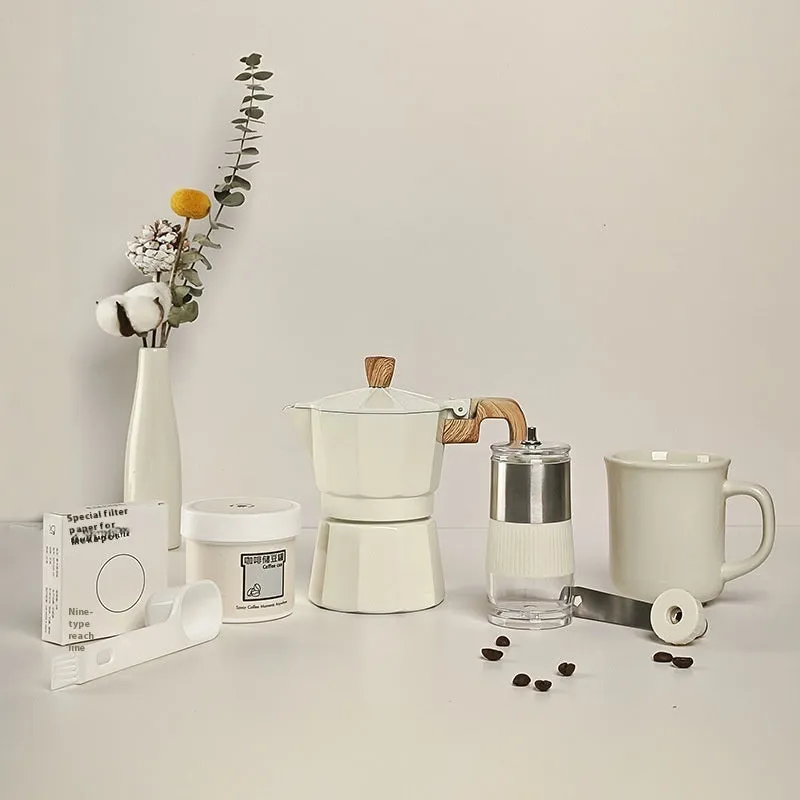 Six-piece manual grinding machine set in beige and black with moka pot, cup, bean jar, and accessories