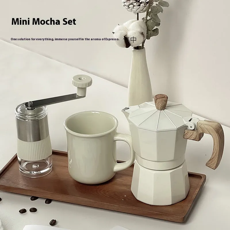 Six-piece manual grinding machine set in beige and black with moka pot, cup, bean jar, and accessories