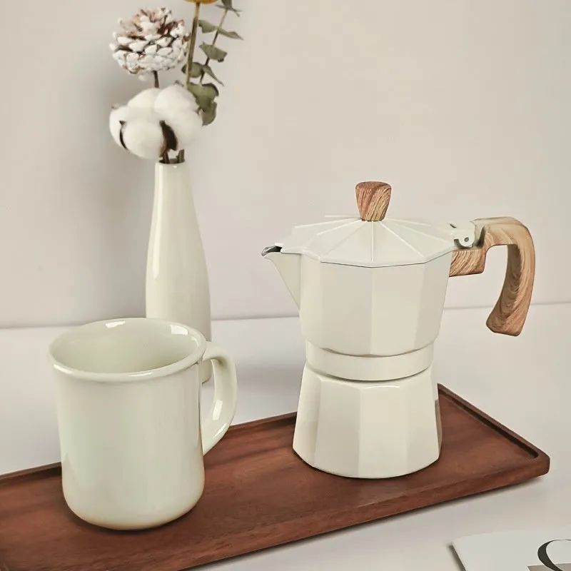 Six-piece manual grinding machine set in beige and black with moka pot, cup, bean jar, and accessories