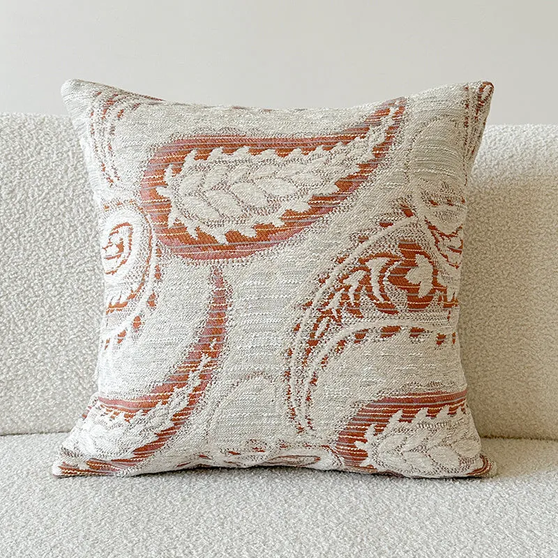 Amber American-style jacquard pillow cover with paisley and flower pattern on a sofa.