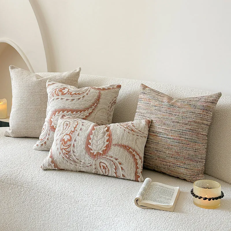 Amber American-style jacquard pillow cover with paisley and flower pattern on a sofa.