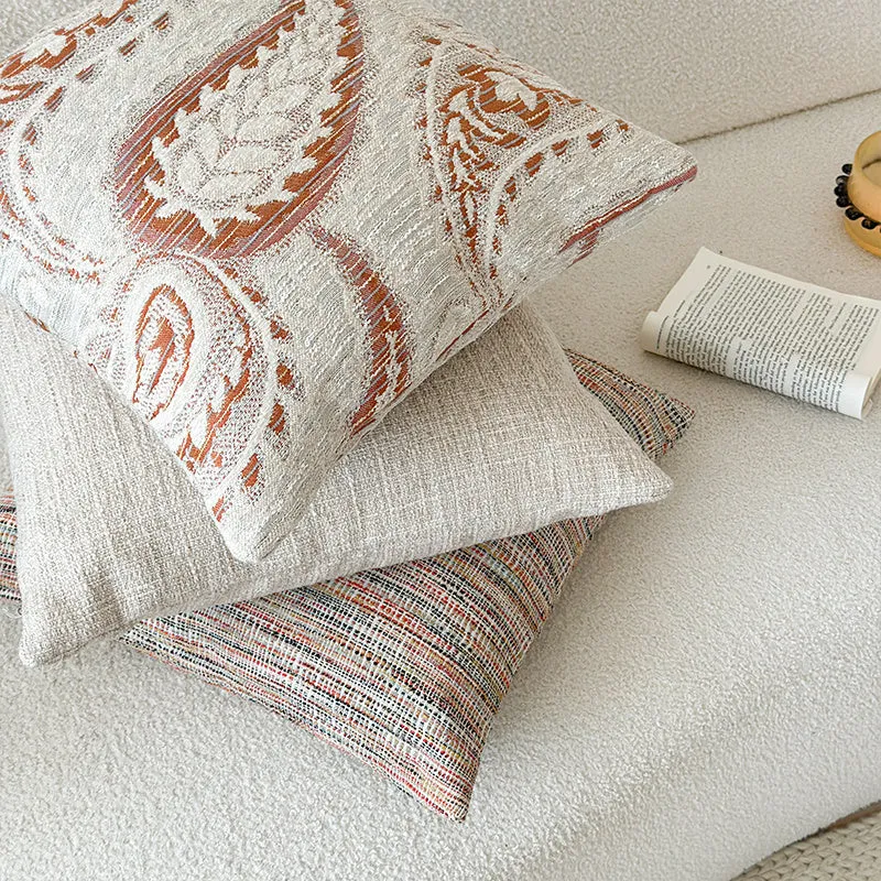 Amber American-style jacquard pillow cover with paisley and flower pattern on a sofa.