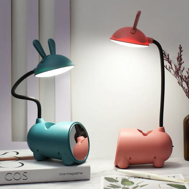 Cartoon-style USB table lamp with integrated pen container in green colour on wooden desk