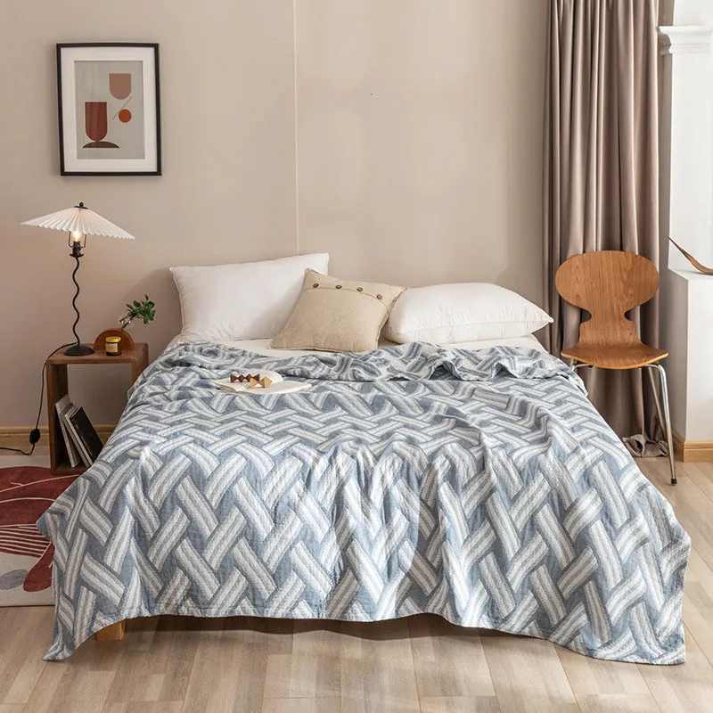 Pure cotton washed cover blanket with geometric pattern in glini pink, folded on a bed
