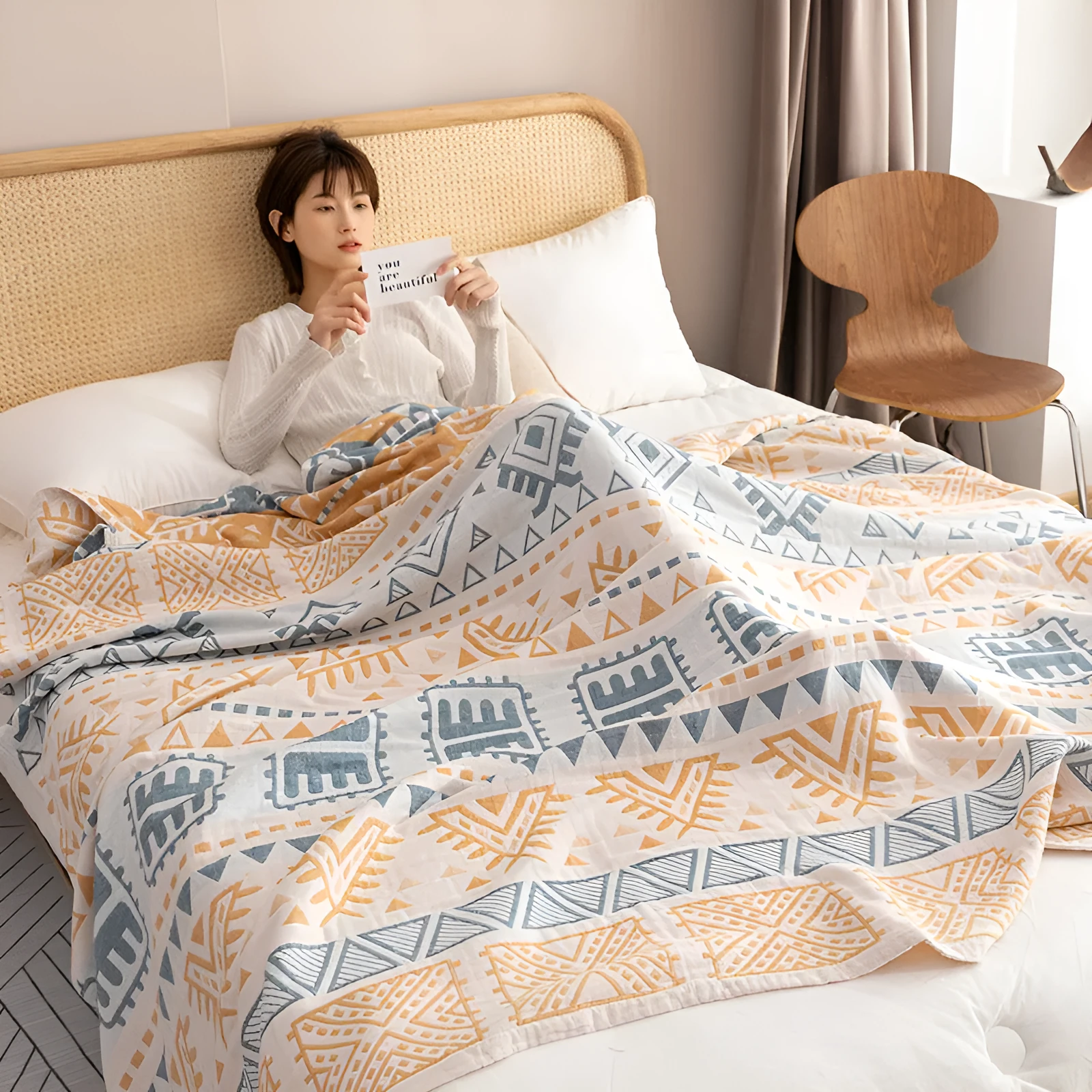 Pure cotton washed cover blanket with geometric pattern in glini pink, folded on a bed