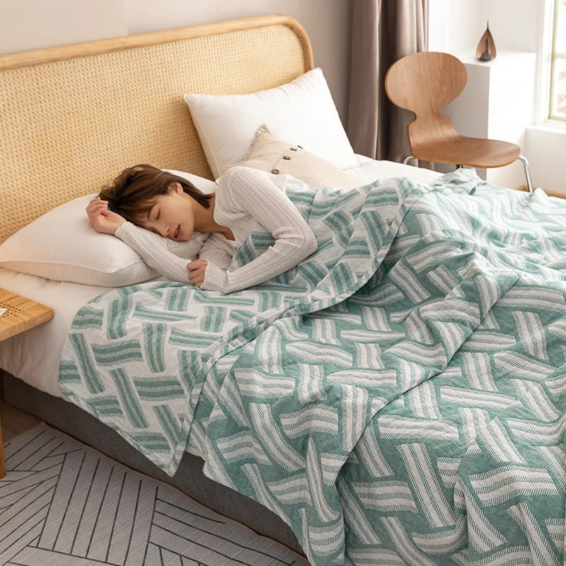 Pure cotton washed cover blanket with geometric pattern in glini pink, folded on a bed
