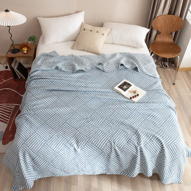 Pure cotton washed cover blanket with geometric pattern in glini pink, folded on a bed