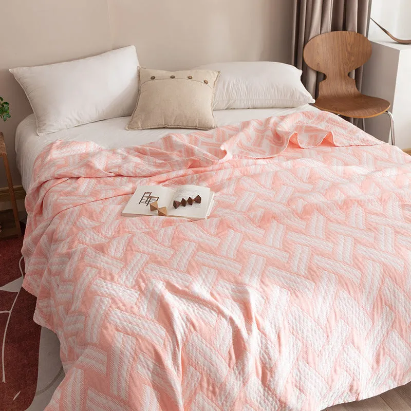 Pure cotton washed cover blanket with geometric pattern in glini pink, folded on a bed