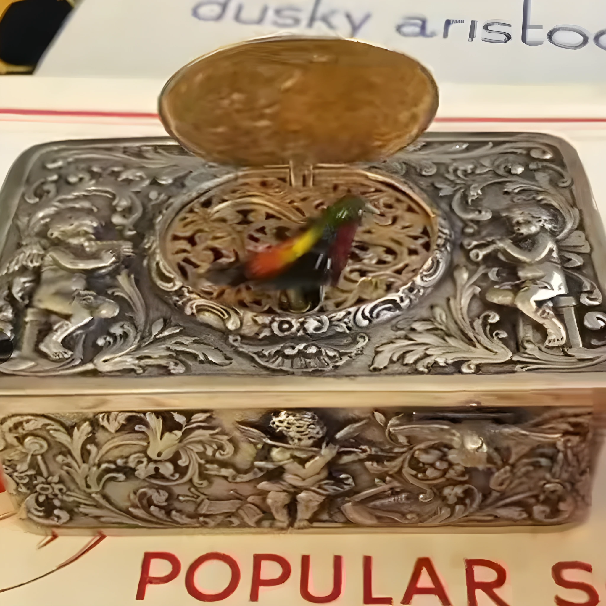 Gold alloy automatic pop-up bird box decoration on a tabletop, 10x6x4 cm