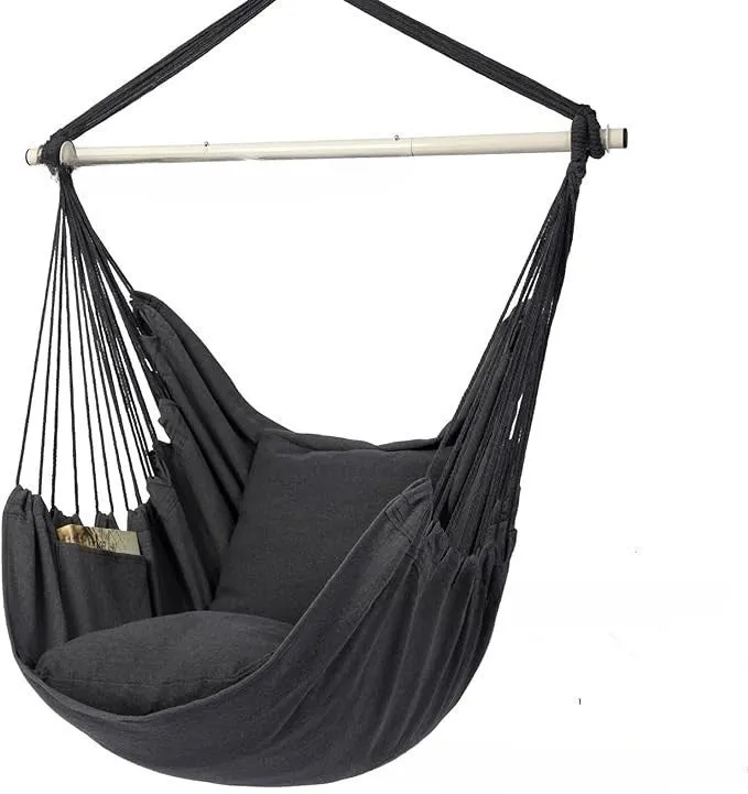 Folding canvas hammock in beige with seat cushion and three-section iron pipe on a garden background