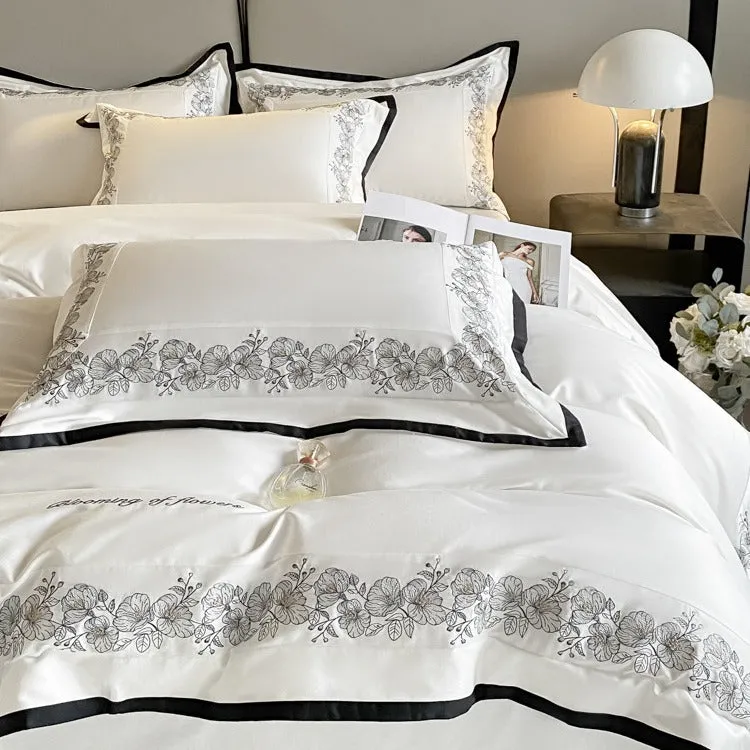 120 thread count pure cotton embroidered four-piece bedding set in solid grey colour on a bed