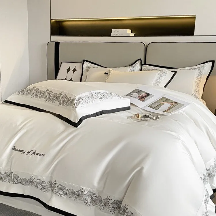 120 thread count pure cotton embroidered four-piece bedding set in solid grey colour on a bed