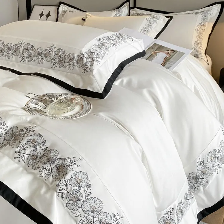 120 thread count pure cotton embroidered four-piece bedding set in solid grey colour on a bed