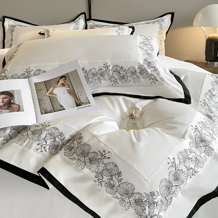 120 thread count pure cotton embroidered four-piece bedding set in solid grey colour on a bed
