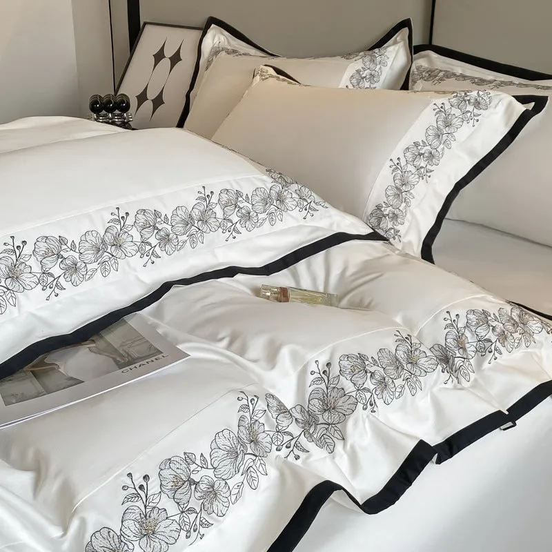 120 thread count pure cotton embroidered four-piece bedding set in solid grey colour on a bed