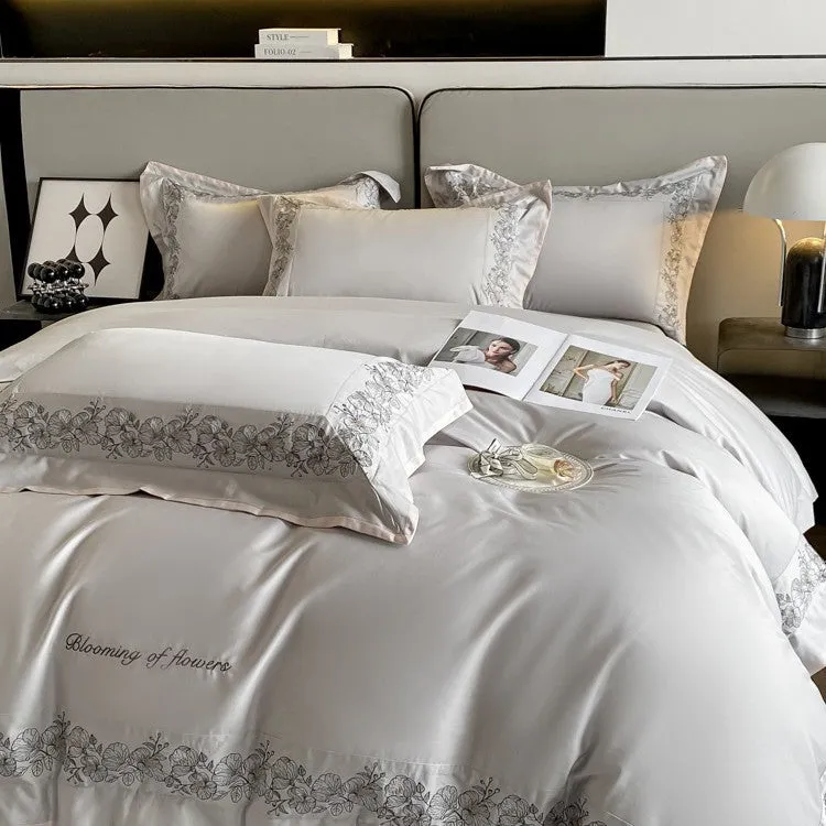 120 thread count pure cotton embroidered four-piece bedding set in solid grey colour on a bed