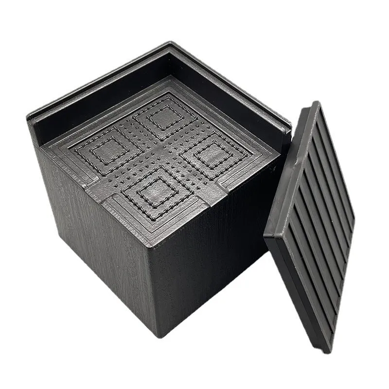 Four black plastic furniture foot mats for height adjustment and floor protection