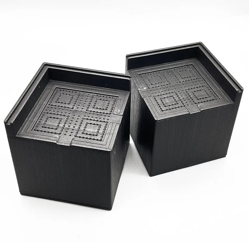 Four black plastic furniture foot mats for height adjustment and floor protection