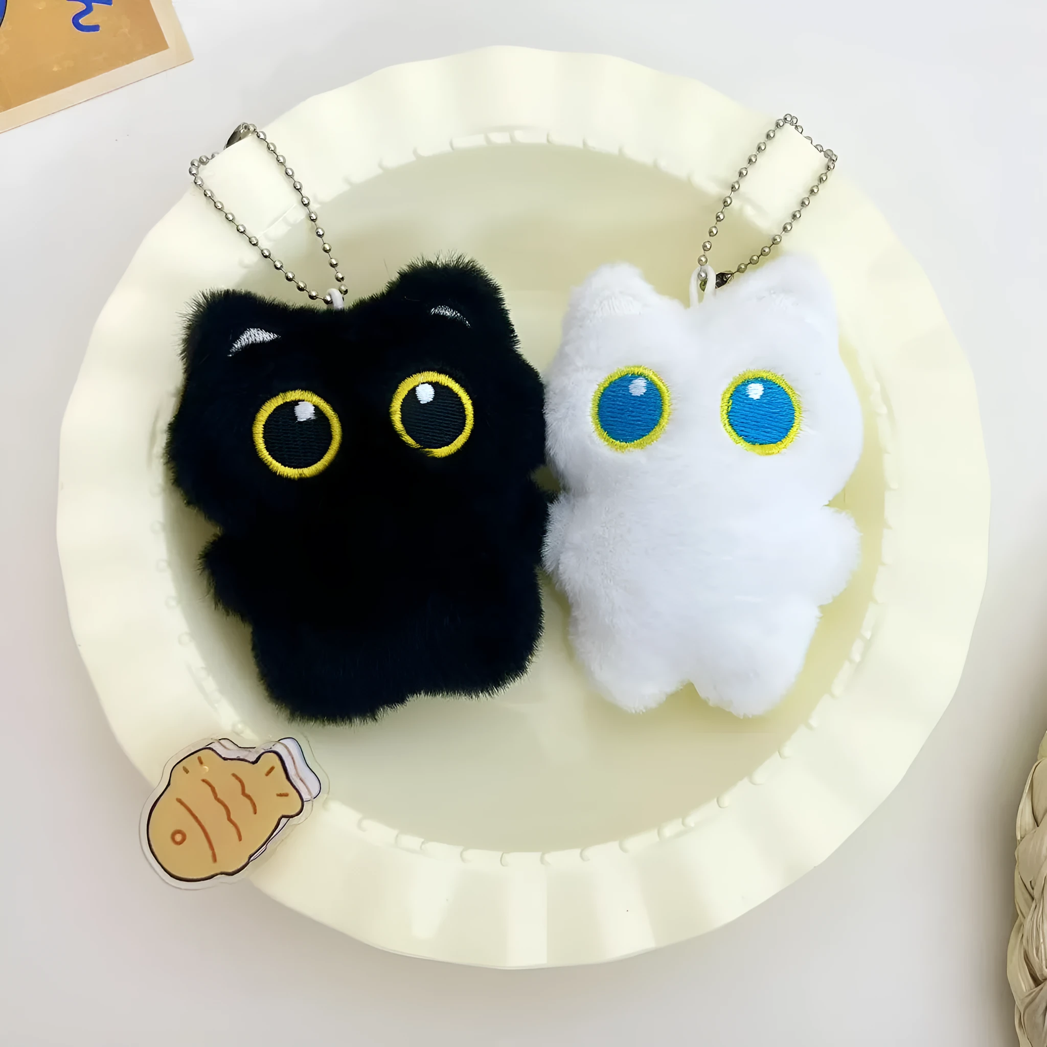 Cartoon big eye black cat doll plush with bead necklace as key decoration on a bag
