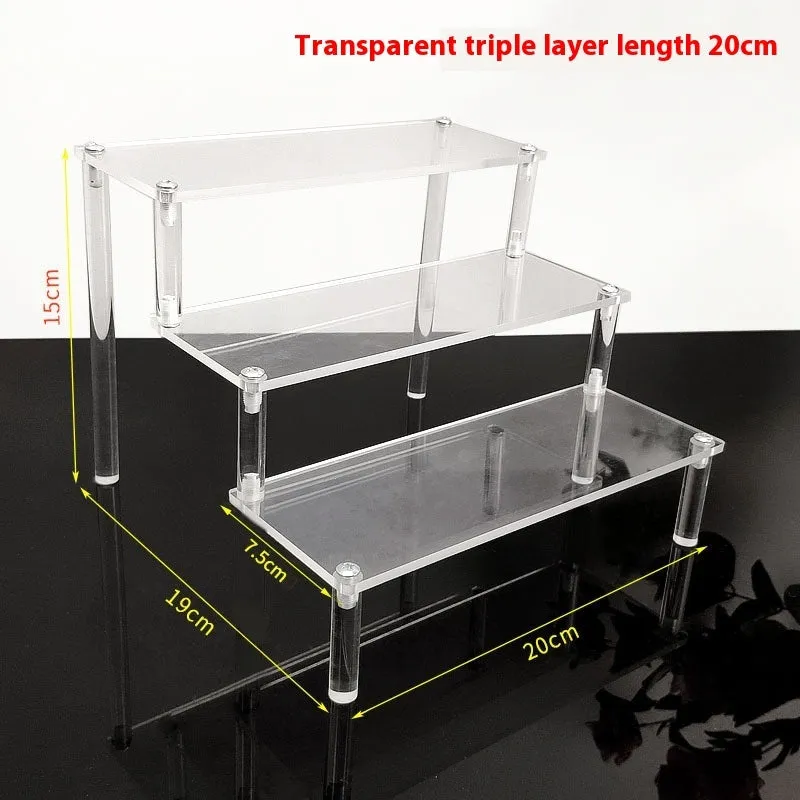 Transparent acrylic ladder display rack with three trapezoidal tiers showing blind box figurines on a desk