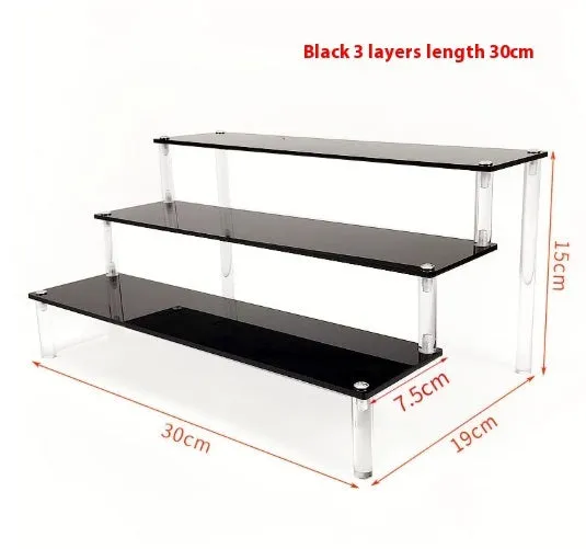 Transparent acrylic ladder display rack with three trapezoidal tiers showing blind box figurines on a desk