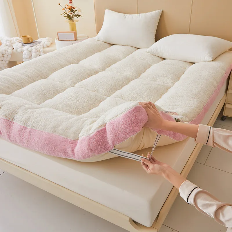 Lambswool mattress cushion with velvet cover in grey and white edge, on a bed
