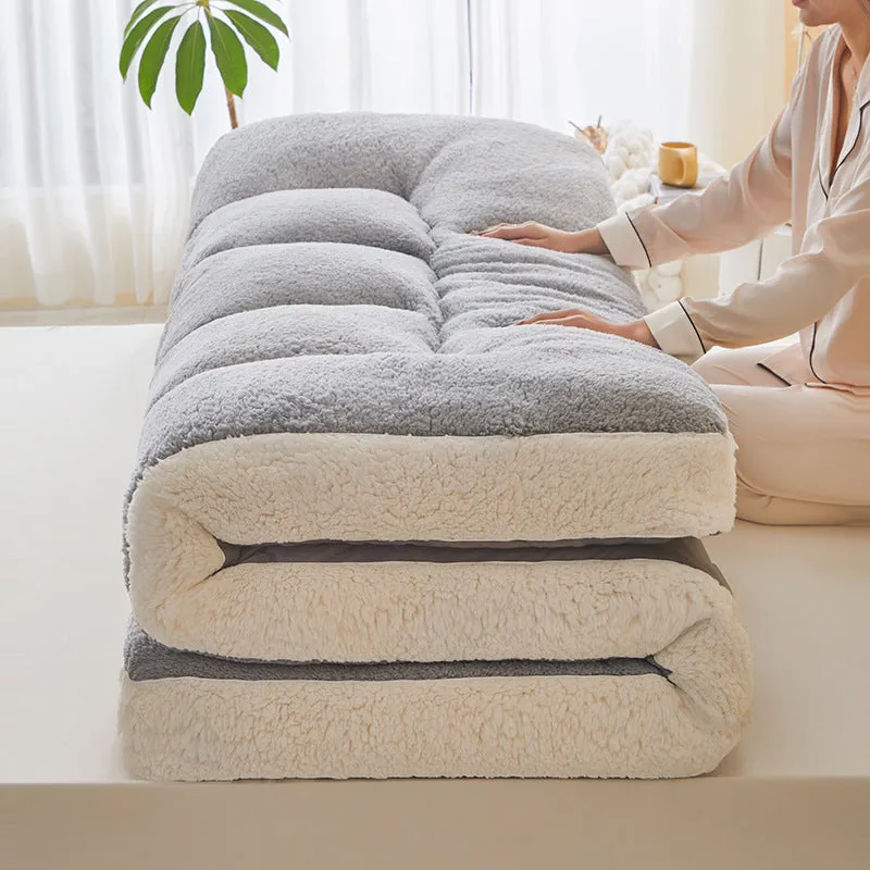 Lambswool mattress cushion with velvet cover in grey and white edge, on a bed