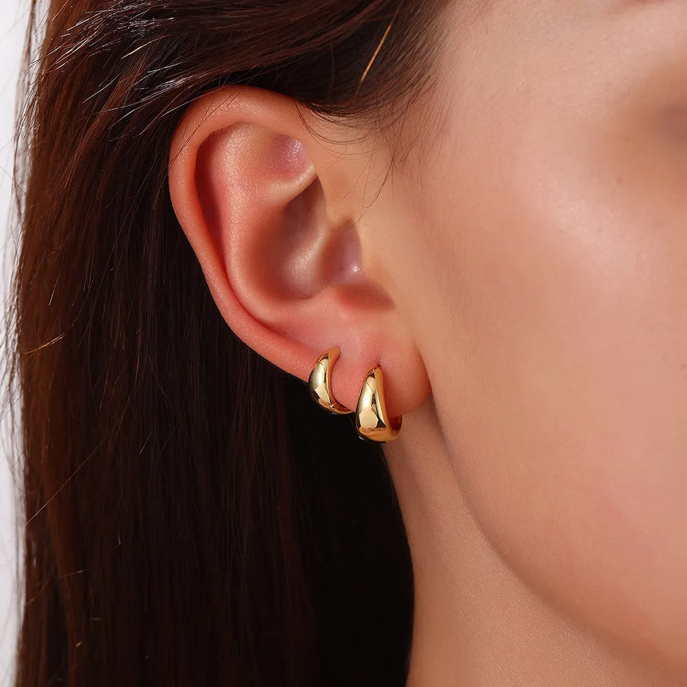 Drop-shaped copper earrings set of three sizes in gold finish on a white background