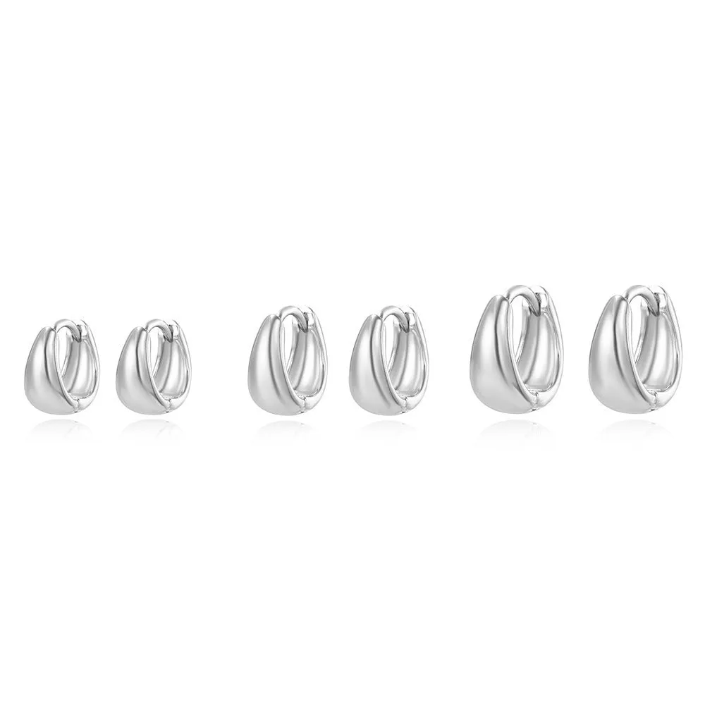 Drop-shaped copper earrings set of three sizes in gold finish on a white background
