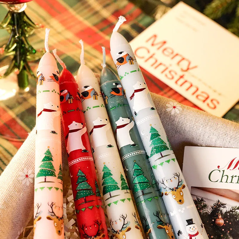 Cylindrical Christmas printed paraffin candle in bright red, 2.2 x 25 cm, on a wooden table