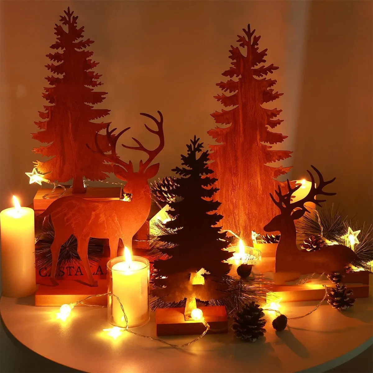 Set of three rusty metal Christmas ornaments featuring elk with antlers and trees, on a white background