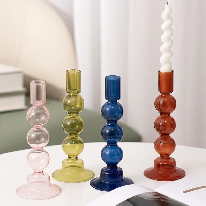 Transparent borosilicate glass three ball mott candle holder in green on a table