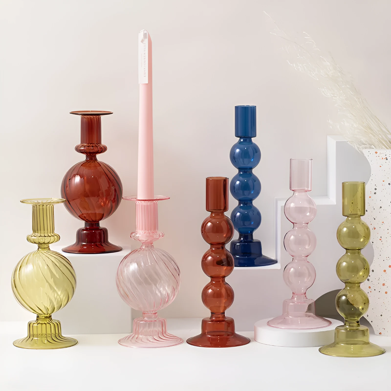 Transparent borosilicate glass three ball mott candle holder in green on a table