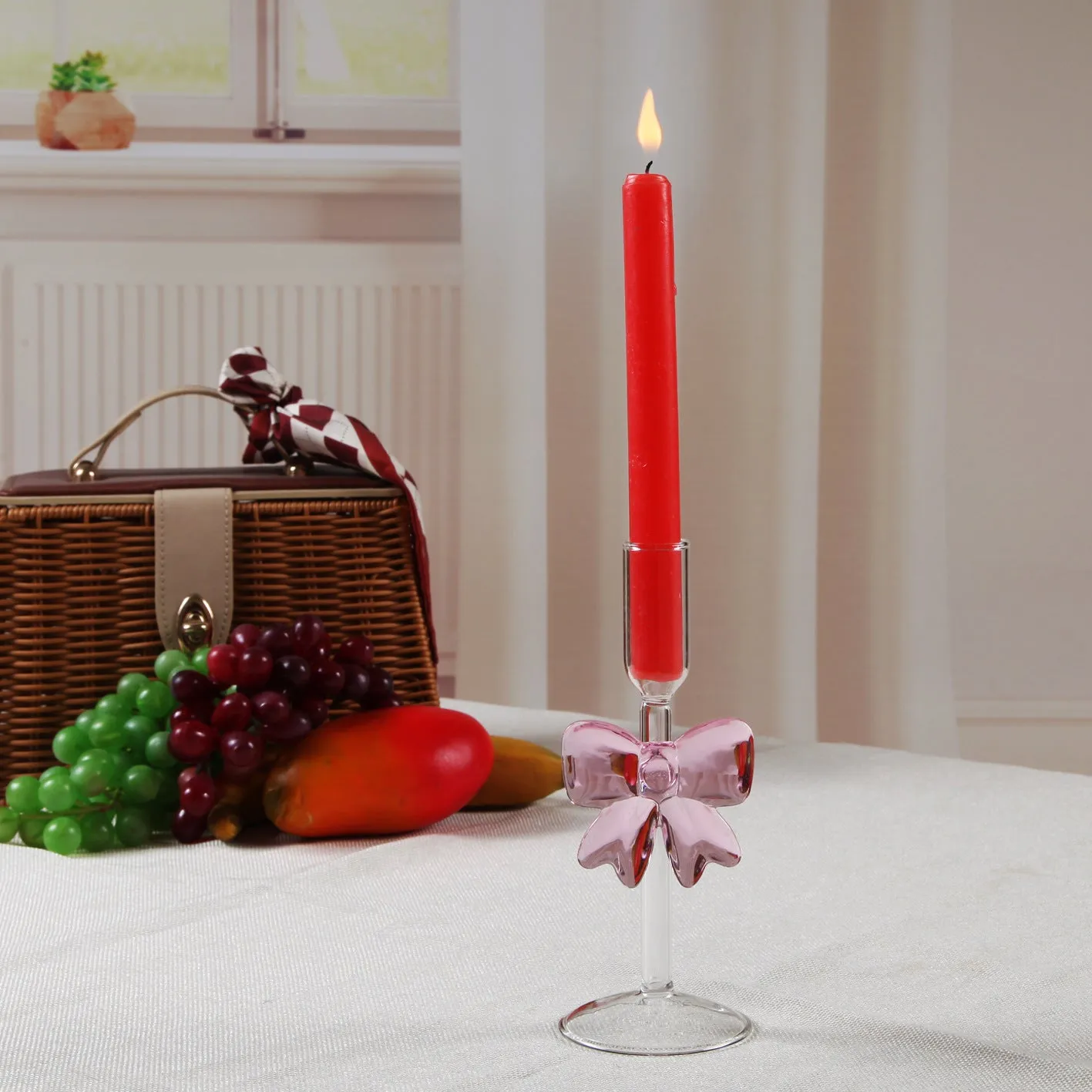Set of three clear borosilicate glass candlesticks with large bow decorations on a table