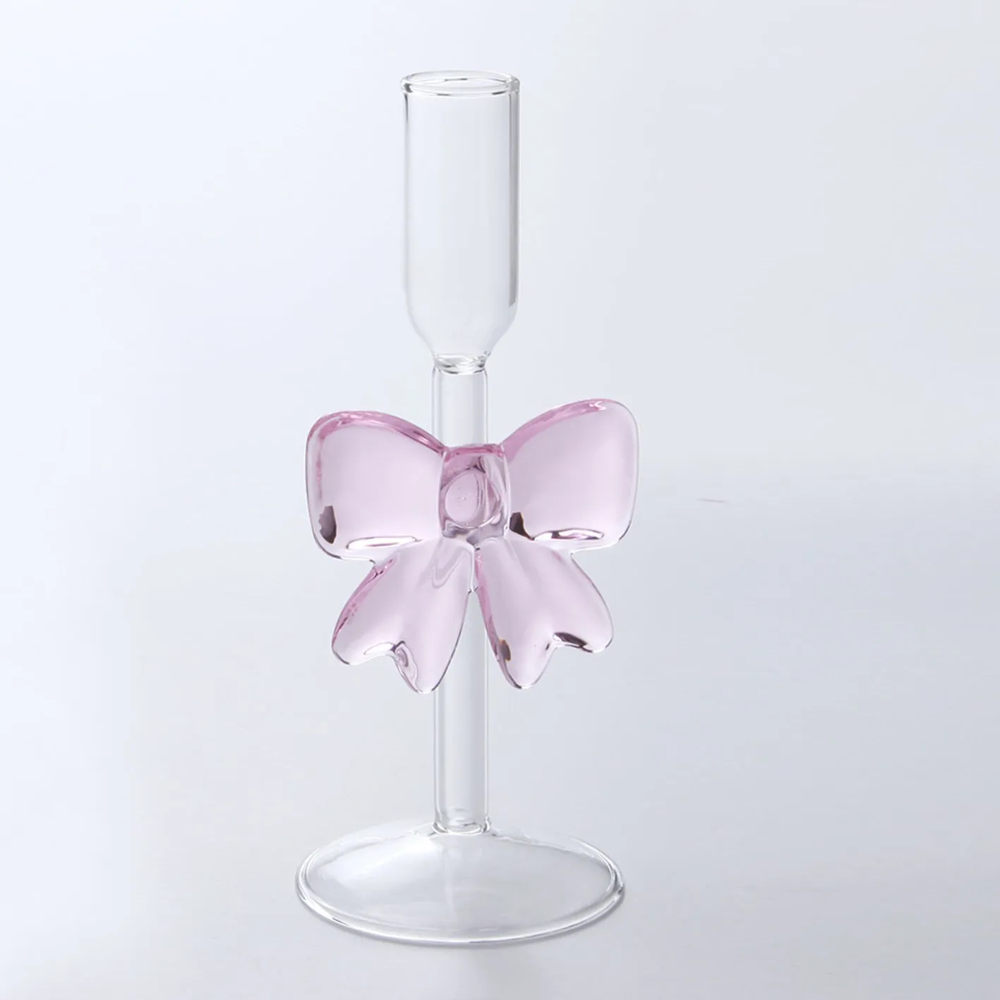 Set of three clear borosilicate glass candlesticks with large bow decorations on a table